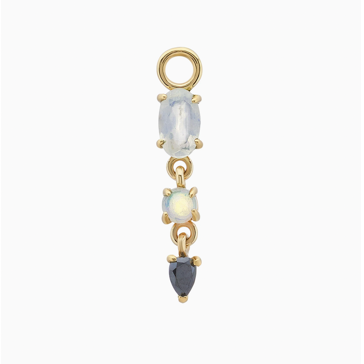 A gold dangle charm featuring three vertically aligned oval and teardrop-cut gemstones in gold prong settings, shown on a plain white background.