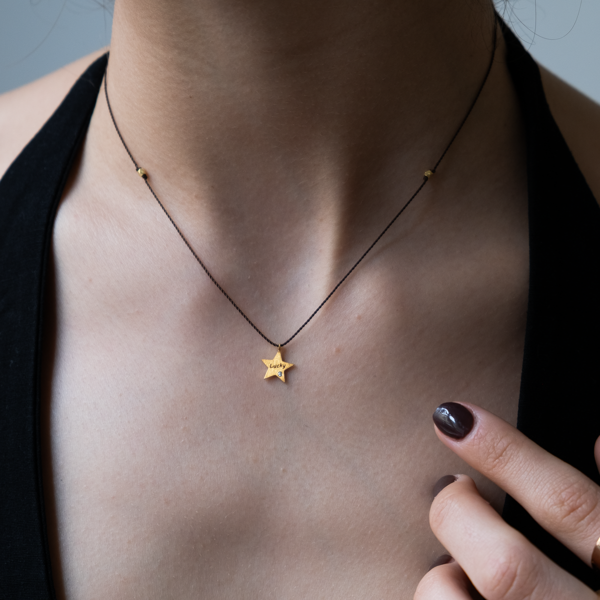 This 14k gold Star charm is engraved with the word "lucky" and adorned with a small diamond. The whimsical Silk necklace is perfect for those seeking subtle yet playful fine jewelry for daily wear. This necklace is an excellent gifting option or a special treat for oneself.